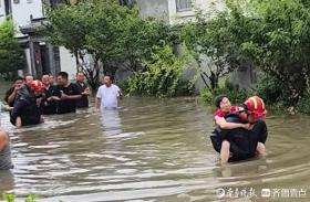 暴雨致岛城多人被困 消防员在齐腰深的水中背老人脱险