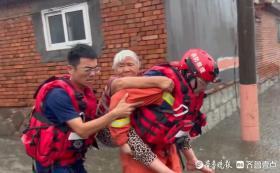 暴雨致岛城多人被困 消防员在齐腰深的水中背老人脱险